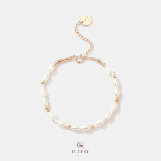 Adorn your wrist with this elegant freshwater pearl bracelet, featuring a series of strong luster rice-shaped pearls. Interspersed with round pearls and tiny 18K gold-plated beads, it offers a classic yet contemporary appeal.