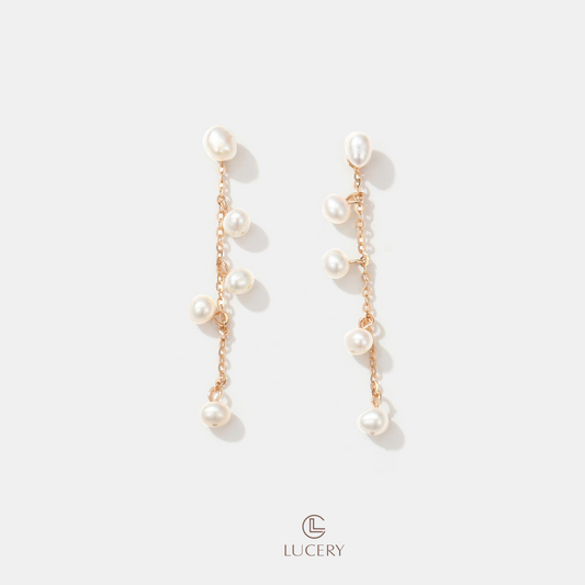 Our Pearl Cascade Chain Earrings are a symphony of sophistication, with each pearl set along a delicate chain, creating an elegant flow from lobe to shoulder.