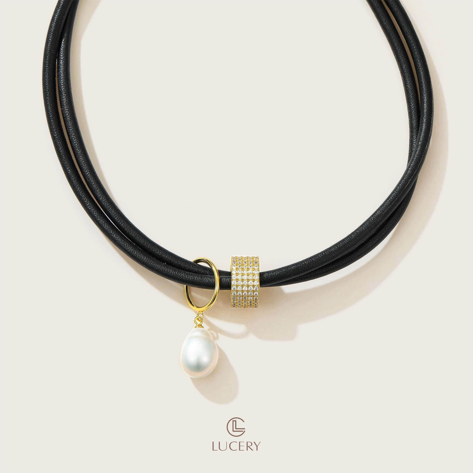 This necklace brings together the contrasting textures of smooth black leather and a single lustrous pearl, accented with a zirconia-encrusted bead. It's a bold piece that redefines elegance with a modern twist.