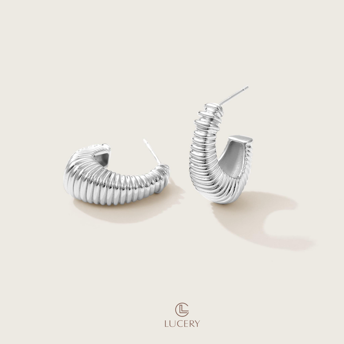 The Sculptural Ribbed Hoop Earrings make a bold statement with their stacked design, offering a contemporary twist on the classic hoop. Their sculpted appearance adds depth and character to any look.