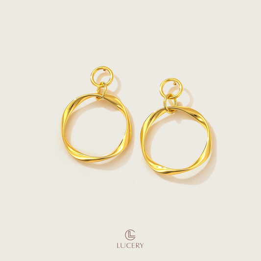 These Geometric Loop Drop Earrings combine simplicity with an edge, featuring an elegant loop design that's both modern and timeless. They dangle with a playful yet polished finesse, adding a golden touch to any ensemble.