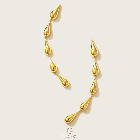 Embrace the fluidity of grace with these Cascading Elegance Earrings, featuring a harmonious series of teardrop shapes that descend with sophistication. Available in classic gold and sleek silver tones, they are perfect for versatile styling and timeless allure.