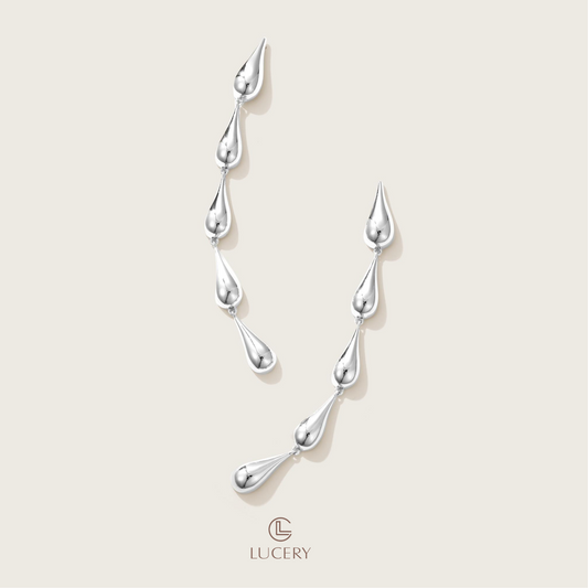 Embrace the fluidity of grace with these Cascading Elegance Earrings, featuring a harmonious series of teardrop shapes that descend with sophistication. Available in classic gold and sleek silver tones, they are perfect for versatile styling and timeless allure.