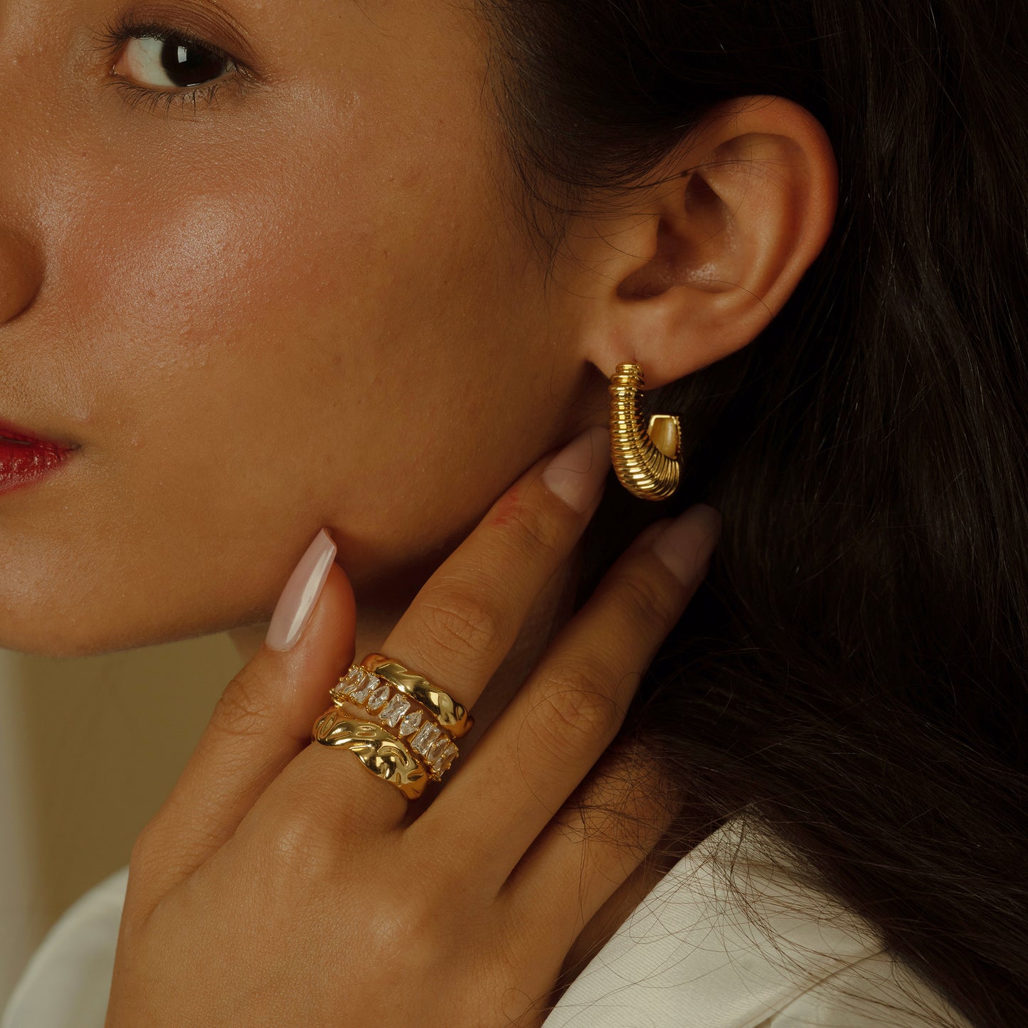 The Sculptural Ribbed Hoop Earrings make a bold statement with their stacked design, offering a contemporary twist on the classic hoop. Their sculpted appearance adds depth and character to any look.